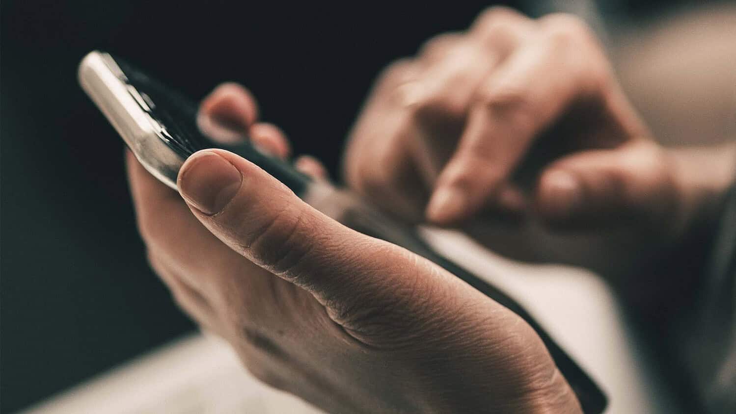Man with cell phone in his hand and finger ready to dial