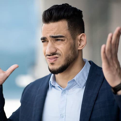 middle eastern man with hands up in frustration