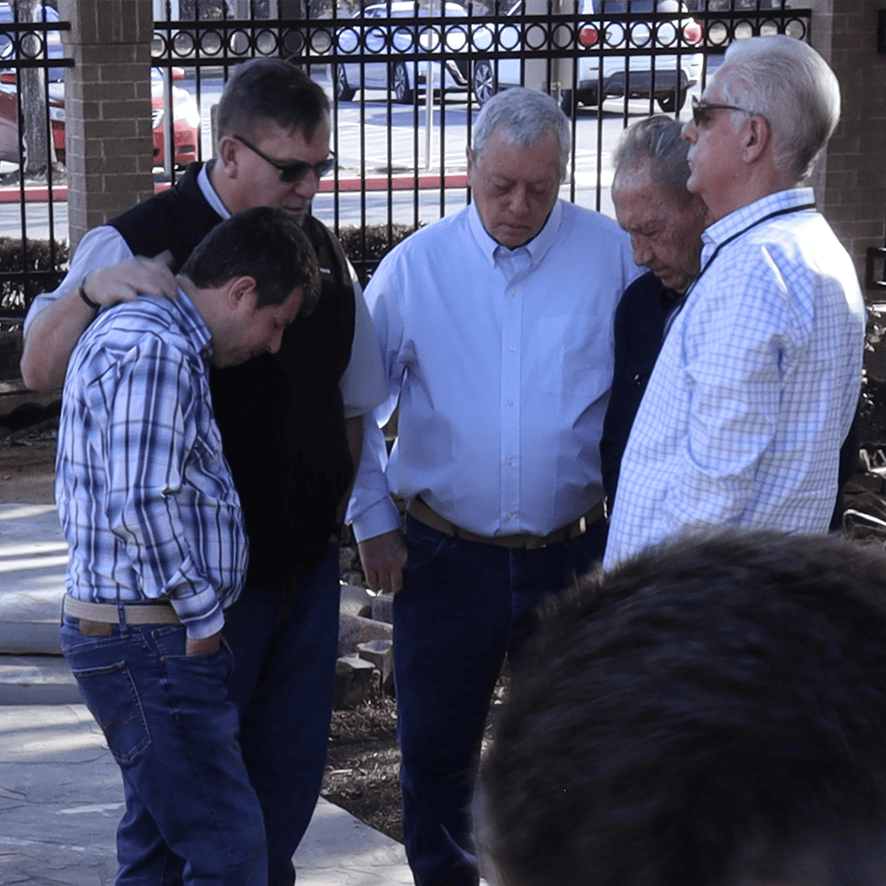 5 men praying outside