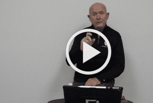 Man standing behind a table with laptop