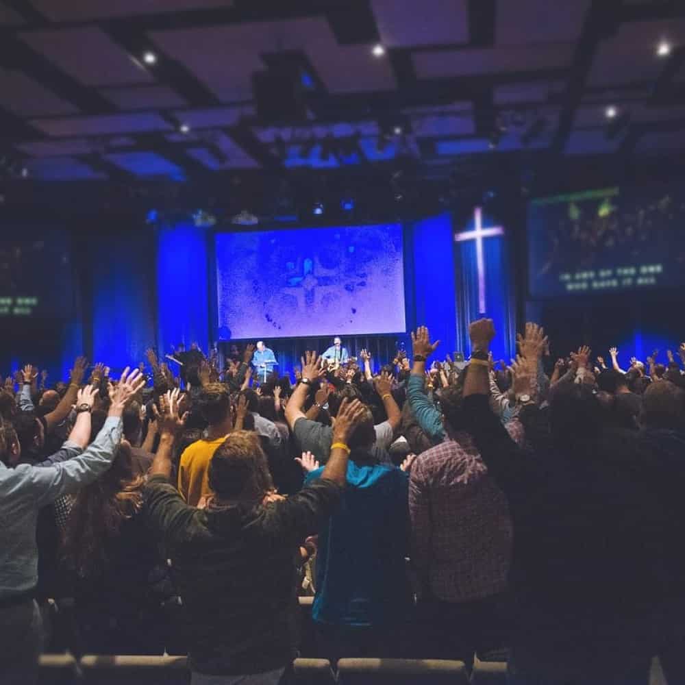 Group of people worshipping at an event.