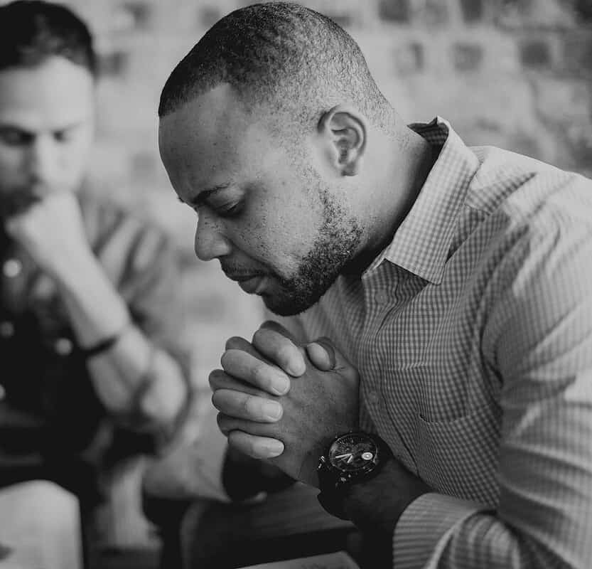 Two men sit and pray
